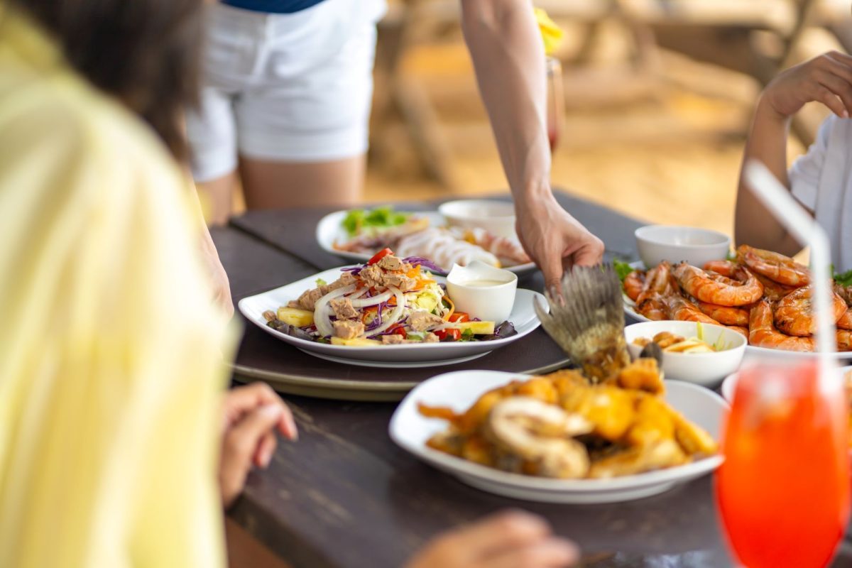 Waiter putting down plate of seafood | New Smyrna Beach Local Guide