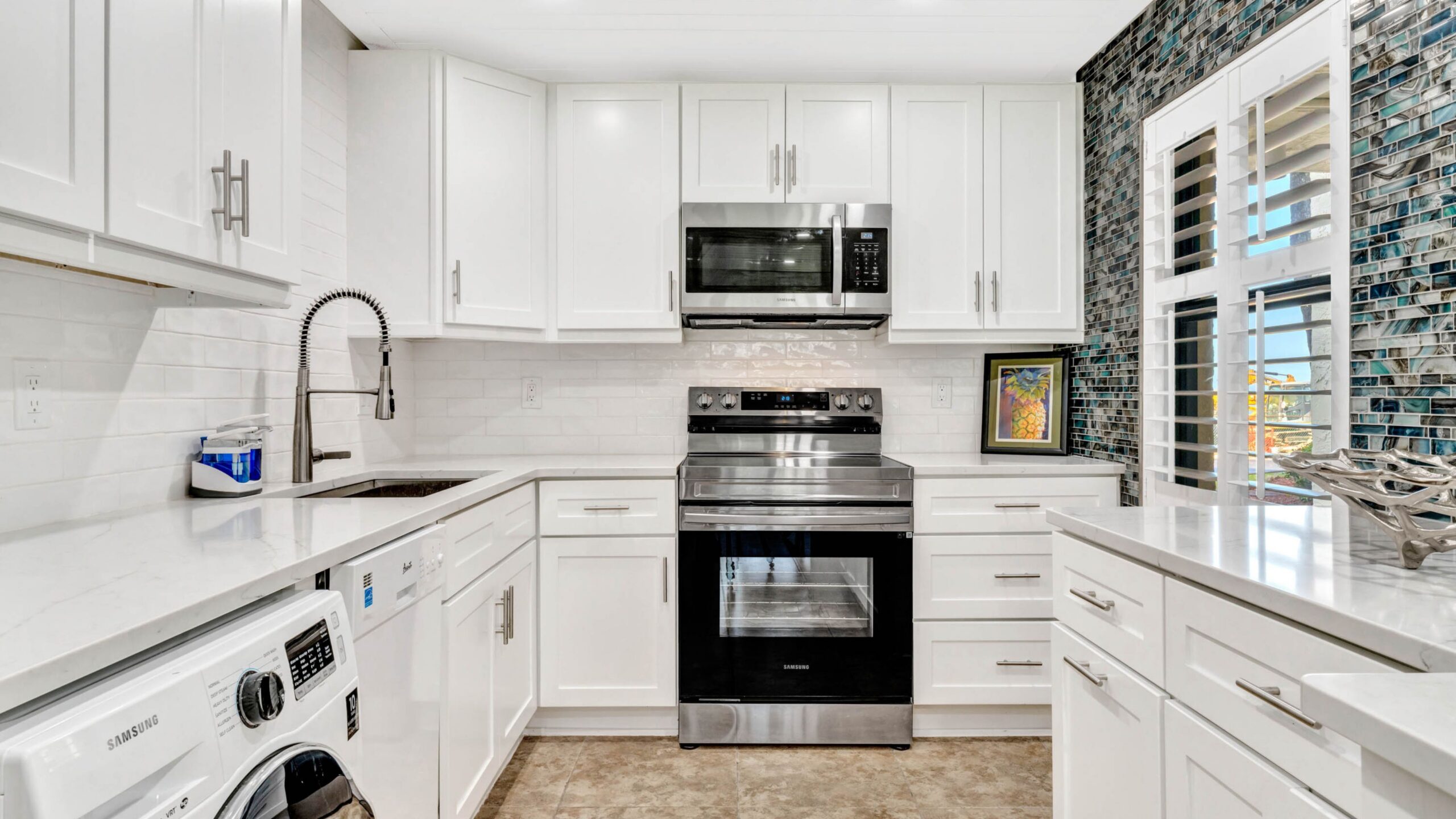 Bright white coastal kitchen at Castle Reef 105 in New Smyrna Beach
