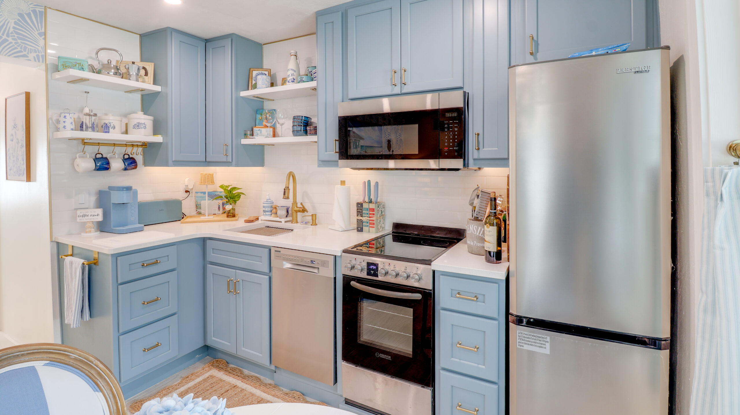 Coastal kitchen at La Casa Del Mar with blue cabinetry and brass hardware