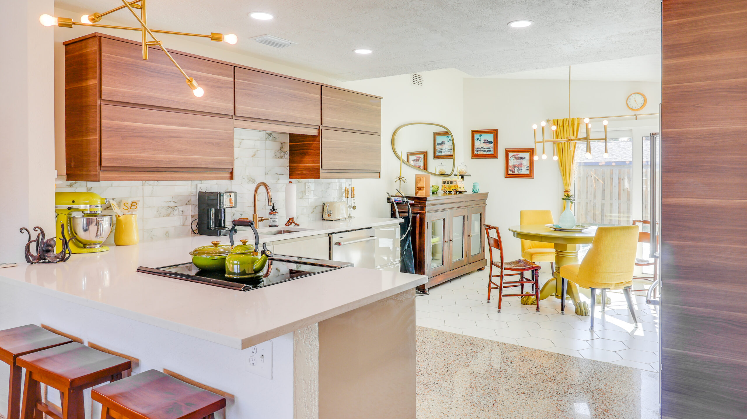 Modern kitchen and dining area at The Octopus Lounge with warm wood cabinetry and yellow accents